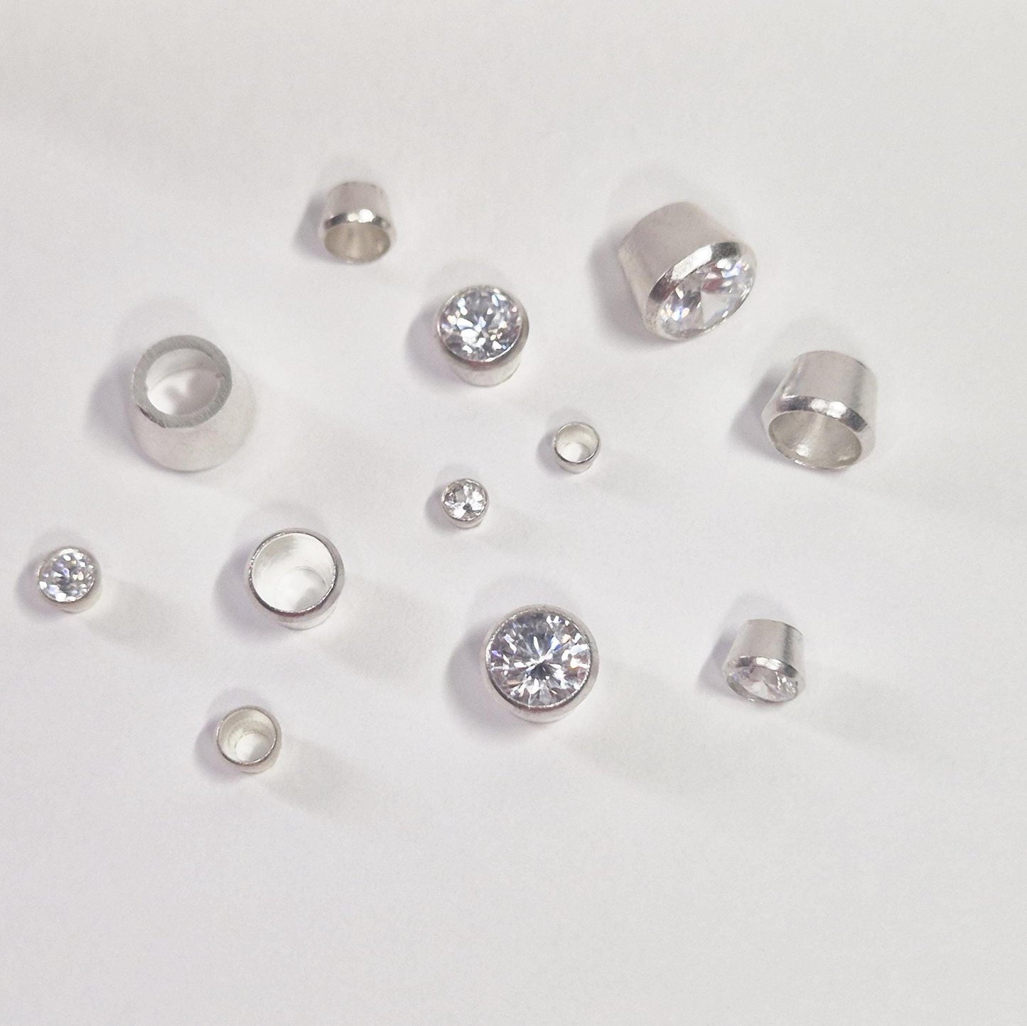 Selection of Round Silver Bezels with some stones set on a white background.