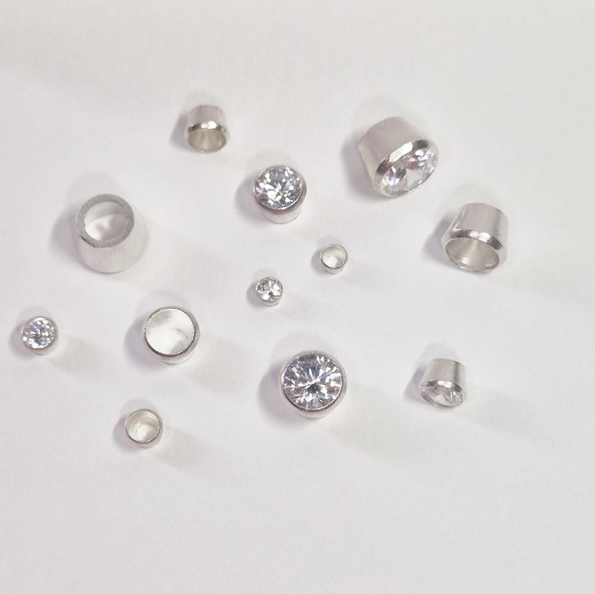 Selection of Round Silver Bezels with some stones set on a white background.