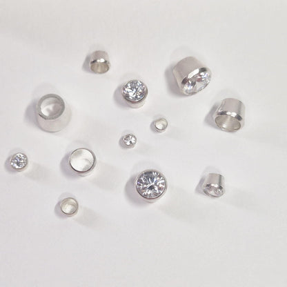 Selection of Round Silver Bezels with some stones set on a white background.