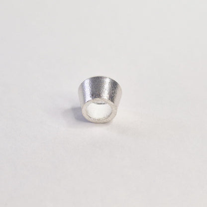 Side view of a sterling silver bezel cup with tapered walls for setting round gemstones or cubic zirconia.