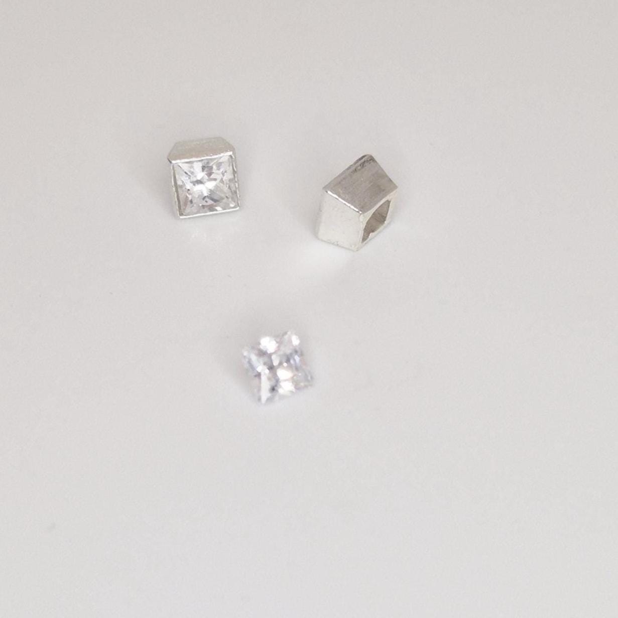 Princess-cut gemstone placed inside square bezel setting, demonstrating fit and proportions