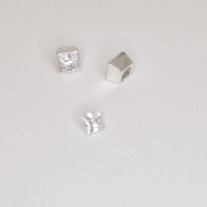 Princess-cut gemstone placed inside square bezel setting, demonstrating fit and proportions