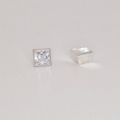 Princess cut square gemstone next to unfinished sterling silver bezel setting viewed from an angle.