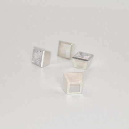 Multiple 7mm square bezel setting components in sterling silver arranged with princess cut gemstone.