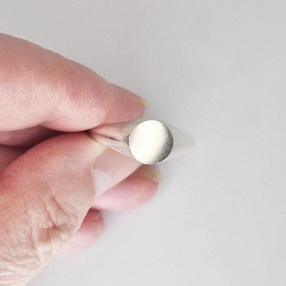 Close-up of round signet ring face, flat circular top ready for engraving, satin finish silver