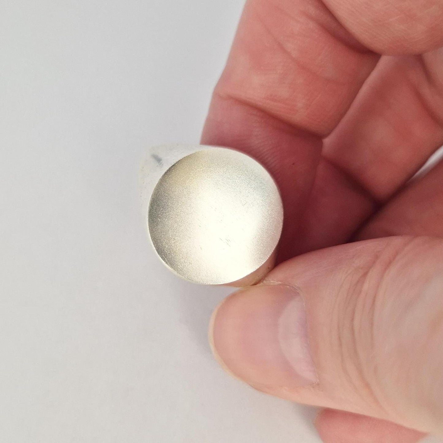 Close-up of 16mm round signet ring face, matte finish, blank for engraving, solid silver