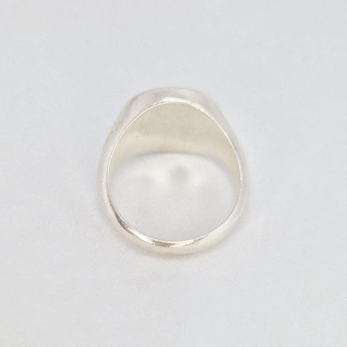 Back view of heavy silver signet ring showing wide shank and thick band profile