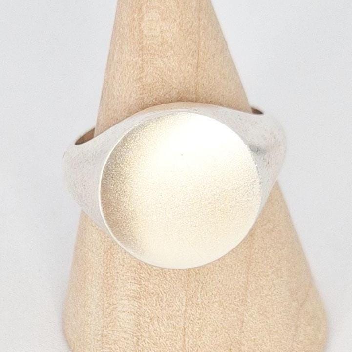 Close-up of 16mm signet ring face on display stand, satin finish silver surface