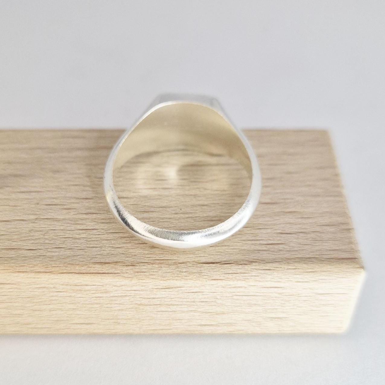 Interior view of silver signet ring band showing smooth inner shank and thickness