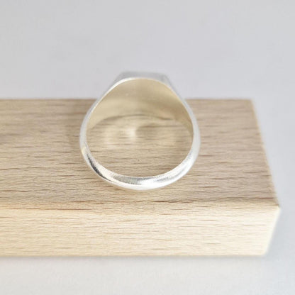 Interior view of silver signet ring band showing smooth inner shank and thickness