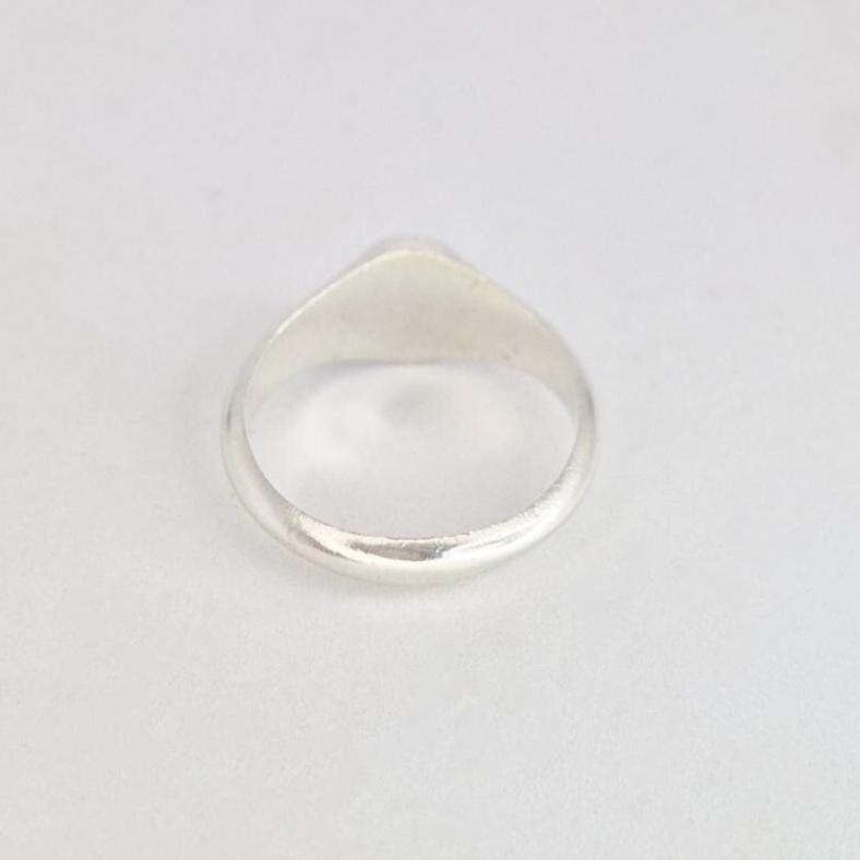 Top-down view of oval signet ring showing smooth band and oval face from above