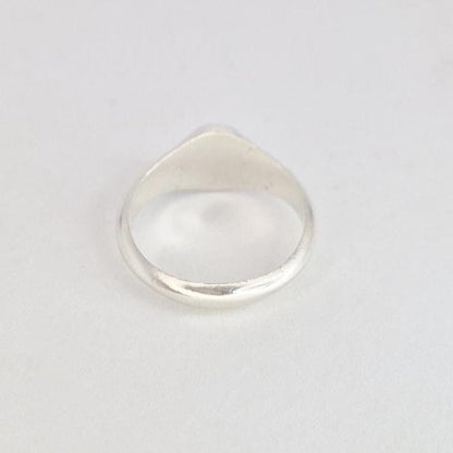 Top-down view of oval signet ring showing smooth band and oval face from above