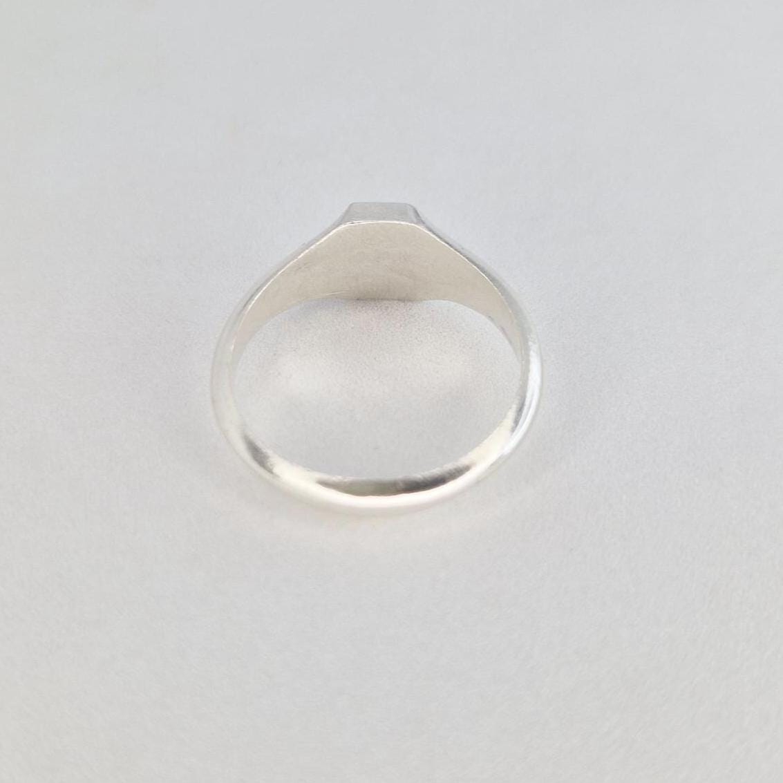 Front view of sterling silver hexagon signet ring with flat hexagonal face and polished shank