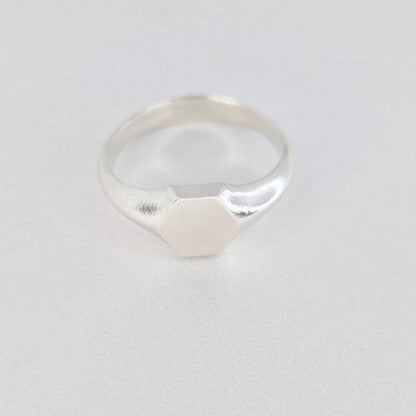 Sterling silver hexagon signet ring front view, clean geometric face with soft satin finish