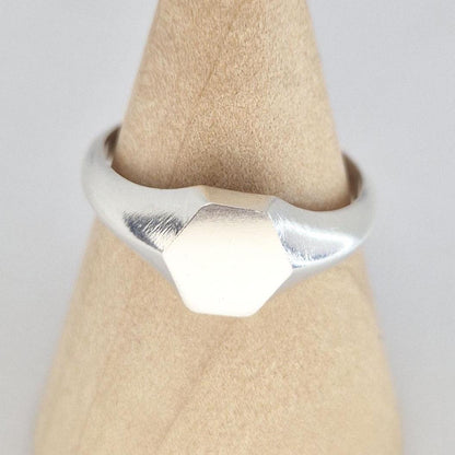 Close-up of hexagon signet ring face in sterling silver, satin finish with polished edges