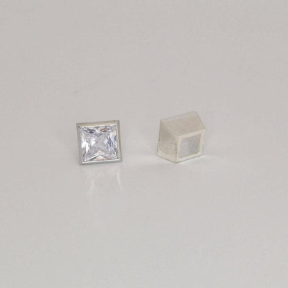 Two-piece sterling silver square bezel setting shown alongside a loose princess cut gemstone.