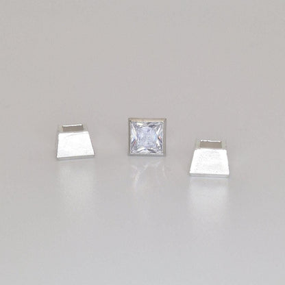 Square bezel setting in sterling silver with princess cut stone placed beside the open setting cup.