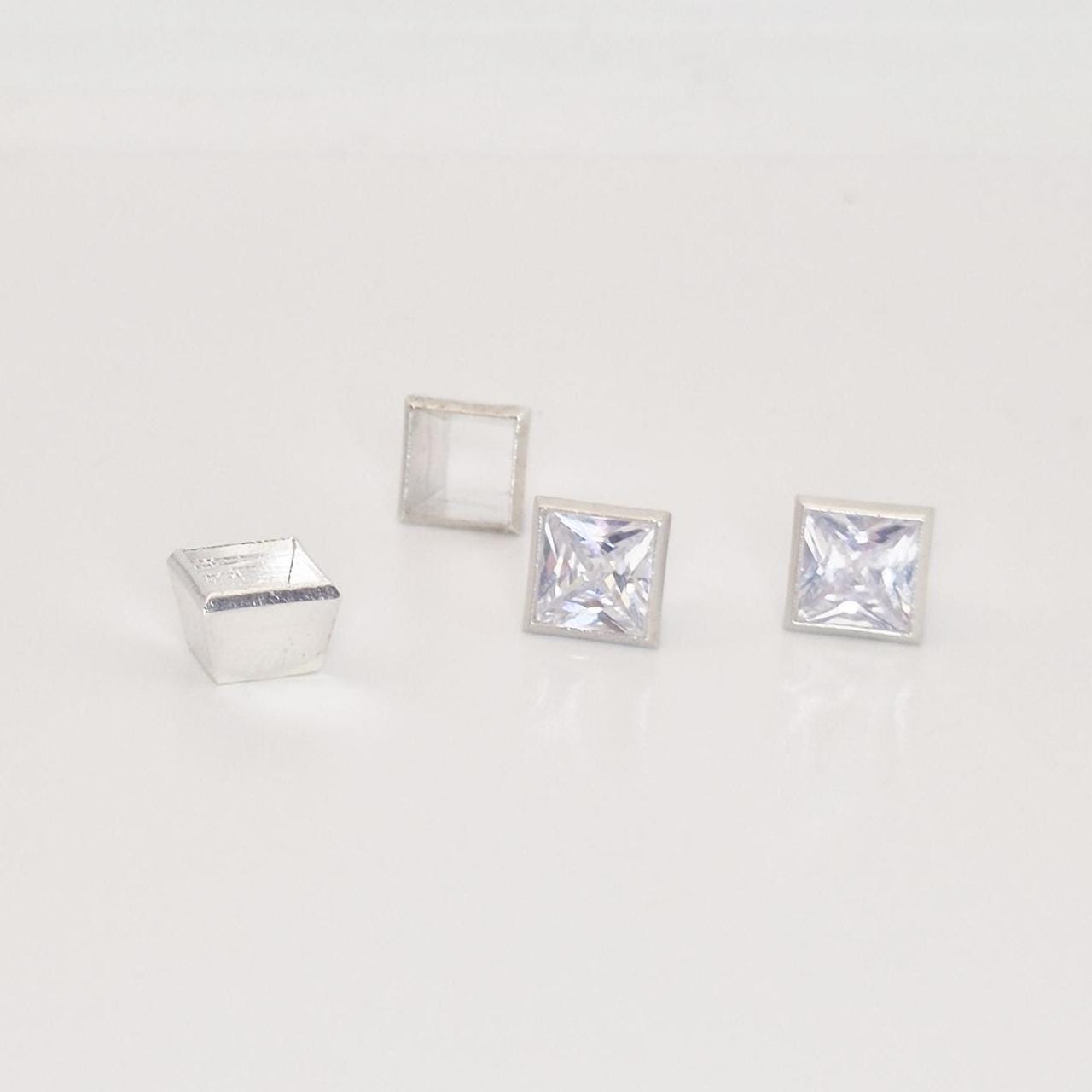 7mm square bezel setting in sterling silver with two princess cut gemstones and empty setting frame.