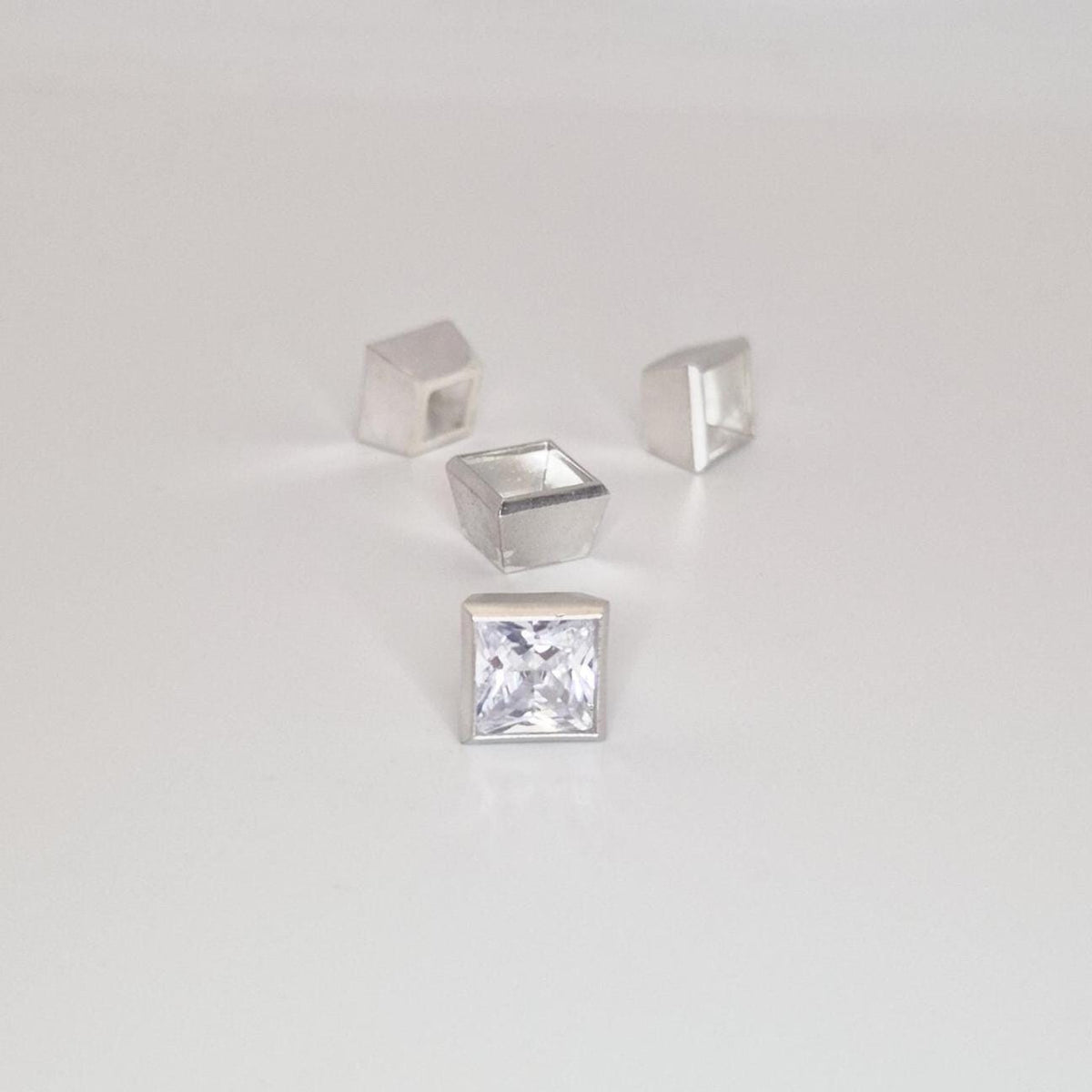 8mm square bezel settings in sterling silver with gemstone and multiple unfinished setting cups.