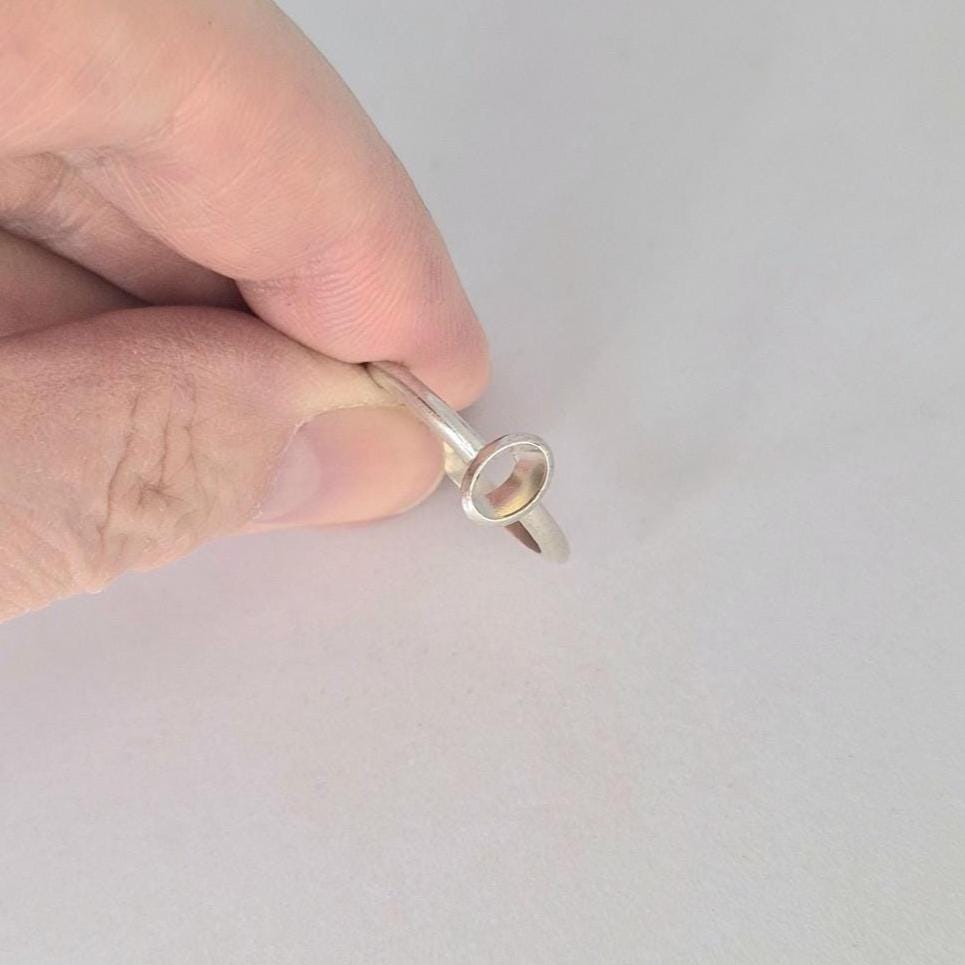 Hand holding a 6x4mm Oval Bezel Ring made in Sterling or Argentium silver to show scale