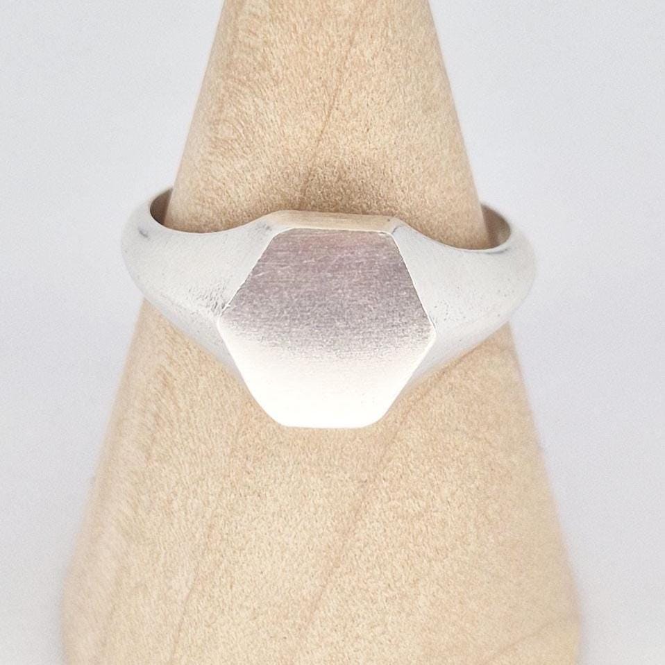Close-up of hexagon signet ring face in sterling silver, matte finish with subtle texture