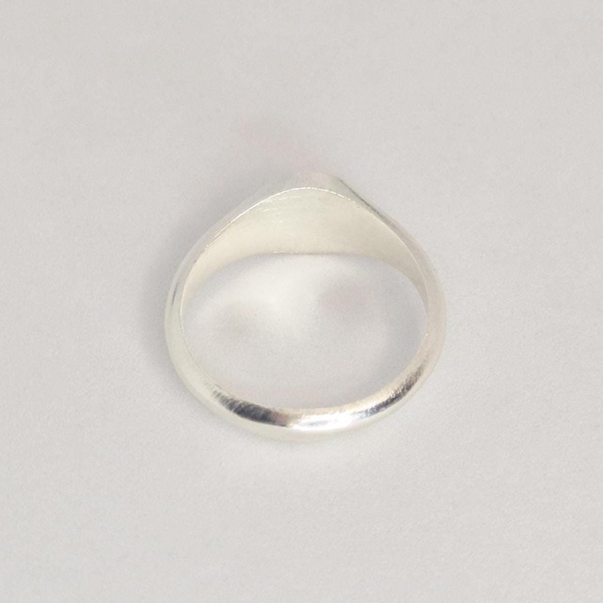 Back view of sterling silver signet ring showing tapered shank and smooth band finish