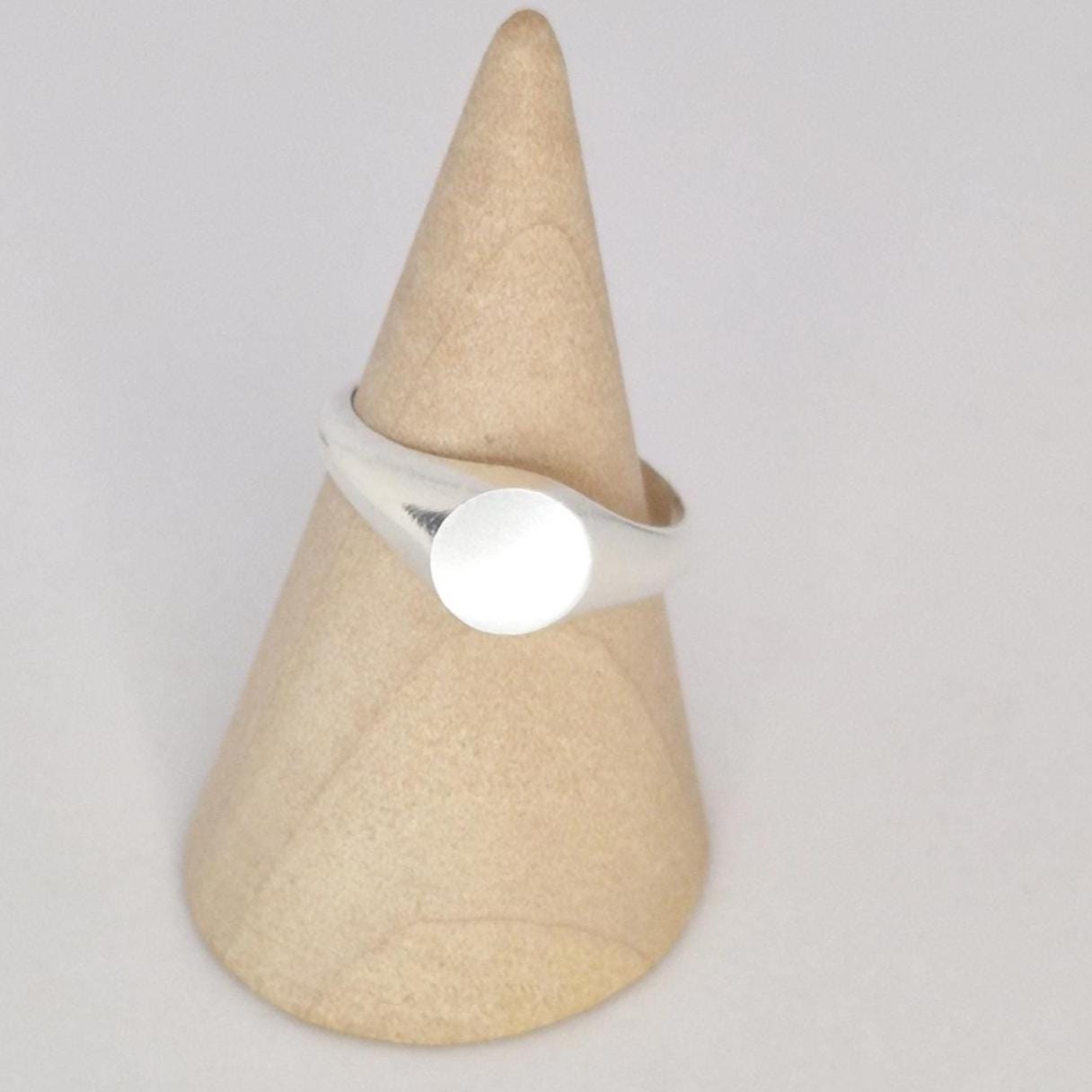 Sterling silver signet ring on cone display stand, blank round face for custom engraving