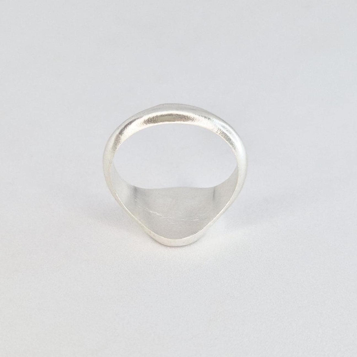 Rear view of a handcrafted silver signet ring showing the smooth tapered band and comfortable inner shank.