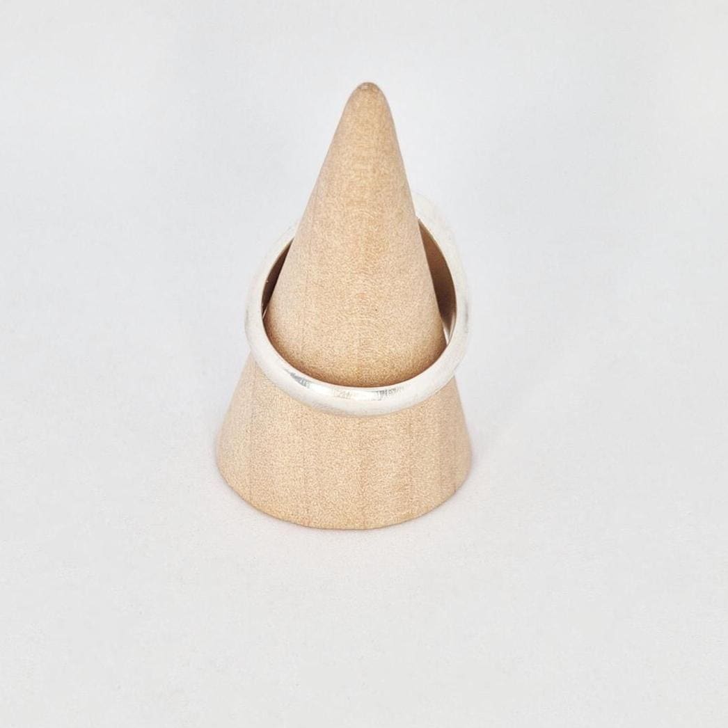 Side view of large round signet ring on cone stand, showing band thickness and taper