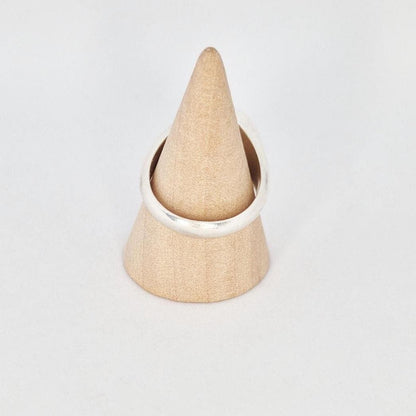 Side view of large round signet ring on cone stand, showing band thickness and taper