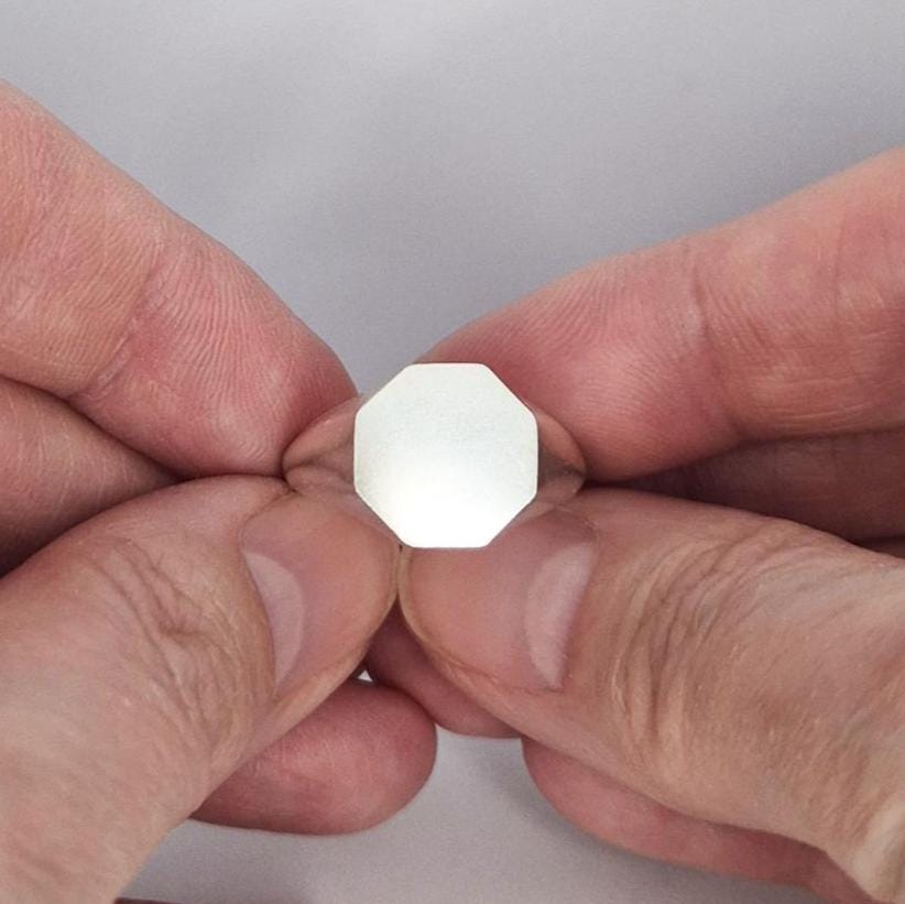 Octagon signet ring blank in sterling or Argentium silver held between fingers, flat engraving face, minimalist jewellery component