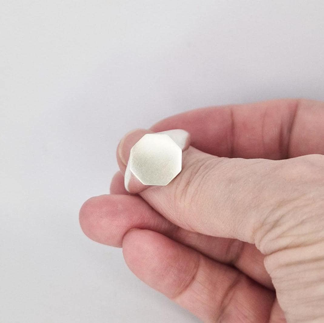 Octagonal signet ring blank angled view showing flat face and tapered shoulders in solid silver