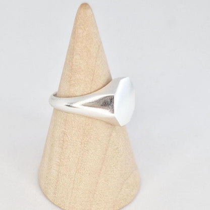 Side view of octagonal signet ring on mandrel showing tapered shoulders and thickness of face