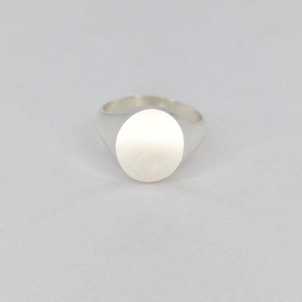 Oval silver signet ring front view with flat matte face on white background