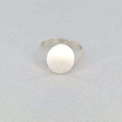Oval silver signet ring front view with flat matte face on white background