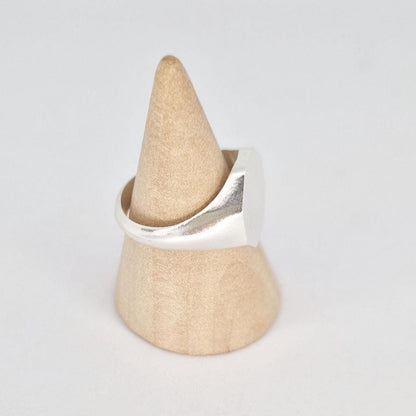 Side view of octagon signet ring on wooden cone stand highlighting tapered shank