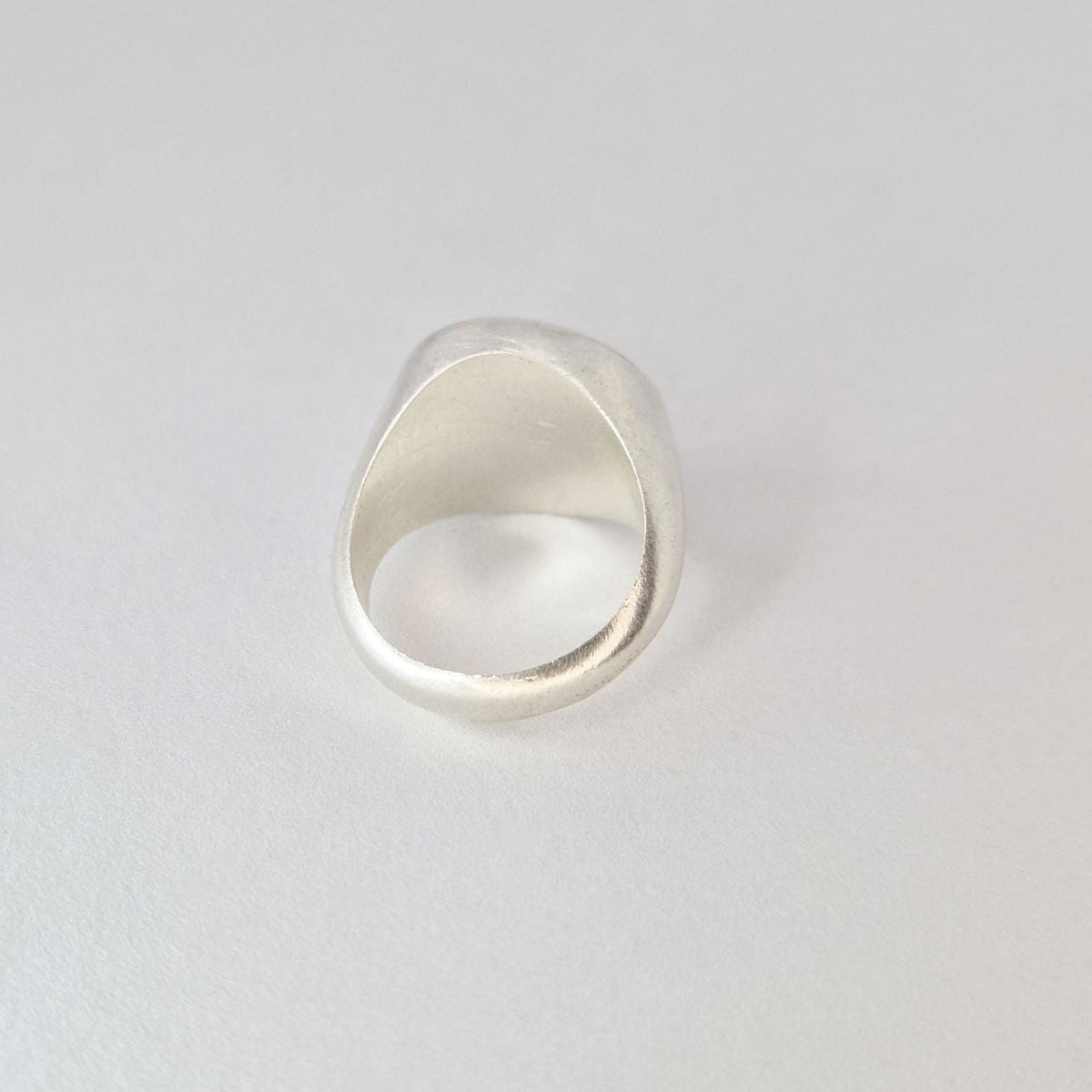 Back view of chunky signet ring showing thick band, smooth inner surface, and tapered shoulders.