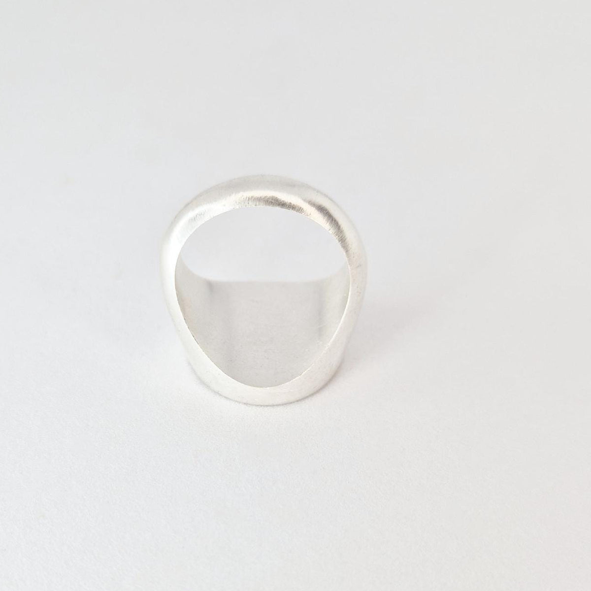 Angled rear view of signet ring highlighting band thickness and solid construction.