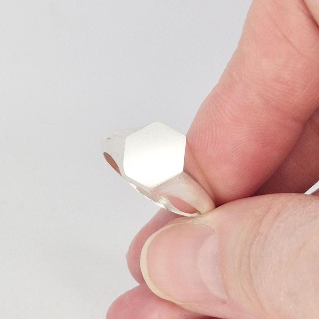 Sterling silver hexagon signet ring angled view, smooth tapered band and flat hex face