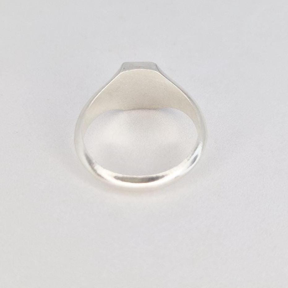 Back view of silver signet ring showing rounded band and smooth polished interior