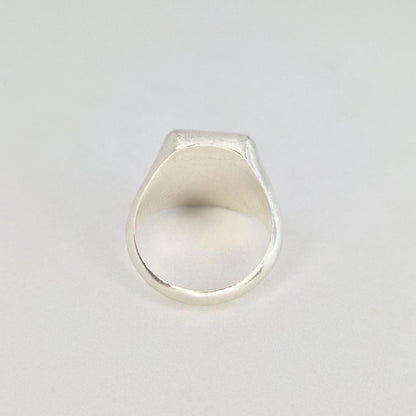 Rear view of a handmade silver signet ring showing the inner band and tapered back profile.