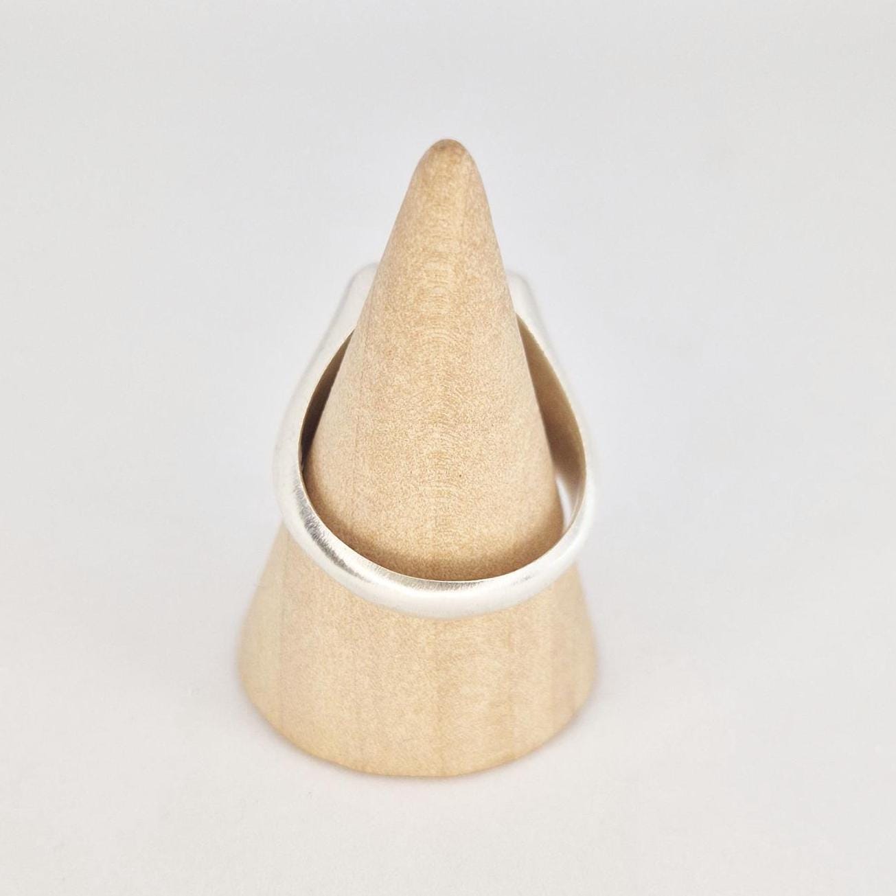 Back view of a cushion signet ring on a wooden cone stand, showing the rounded polished shank and comfortable fit profile.
