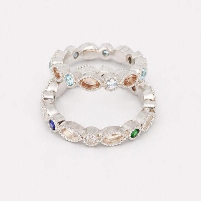 Two stacked Argentium silver birthstone rings with coloured gemstones and marquise bezel settings for memorial resin.